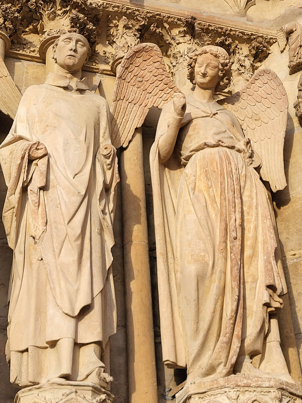 Smug angel statue at Cathedral Notre Dame de Reims, witnessed coronations of French kings, during Chesil Rectory's wine experience